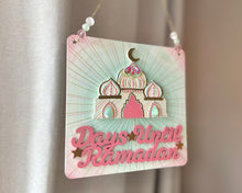 Load image into Gallery viewer, pink mint green and ivory plaque with mini mosque adorned with beads. Writing that says: Days until Ramadan, and it includes a few gold stars. Gold twine to hang, with beads on either side.