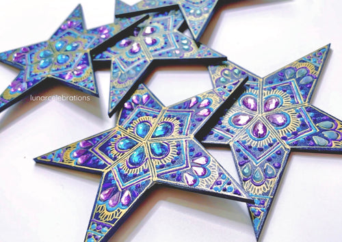 blue wall stars with purple and turquoise painted details and gems