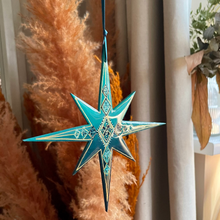 Load image into Gallery viewer, Decorative blue star hanging ornament in a home setting with pampas grass and white curtains.