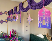 Load image into Gallery viewer, Purple and pink bohemian-style party decorations hanging from a gold rod in a living room, including draped fabric, a crescent moon, stars, and a miniature lantern ornament.